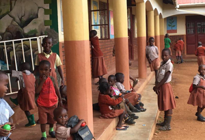 Children sitting in school yard during recess. 
